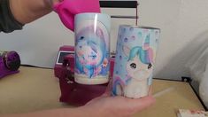 someone is holding two cups with unicorns on them