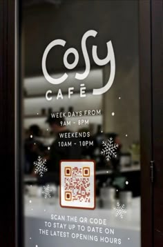 the front window of a coffee shop with snowflakes and qr code on it