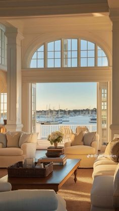 a living room filled with lots of furniture and windows overlooking the water in front of them