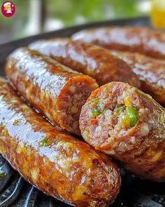 several sausages are stacked on top of each other in a grilling pan next to an orange juice