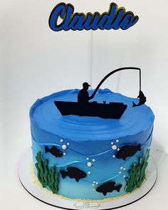 there is a blue cake with a fishing scene on it