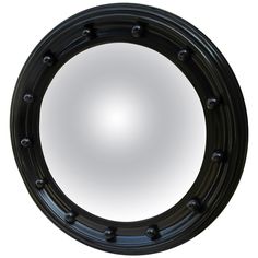 a round mirror with black trim on a white background