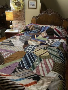 a bed covered in lots of different colored pieces of cloth on it's headboard