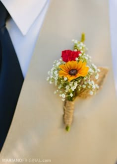 a boutonniere with sunflowers and baby's breath