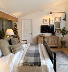 a bed room with a neatly made bed and a flat screen tv