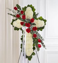 a cross with red and white flowers on it