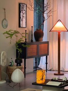 a living room filled with furniture and a tall lamp on top of a wooden table