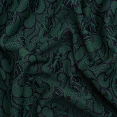 a green and black fabric with an intricate design on the front, it is very soft