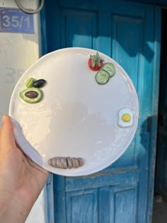 a person holding a plate with food on it in front of a blue door,