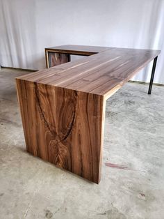 two wooden tables sitting on top of each other in an empty room with white walls