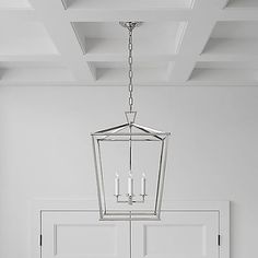 a chandelier hanging from the ceiling in a room with white walls and doors