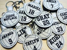 many personalized keychains with names and numbers on them