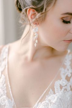 a woman in a wedding dress wearing earrings