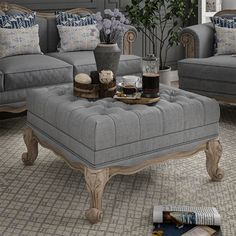 a living room with grey couches and blue pillows on the floor next to a coffee table