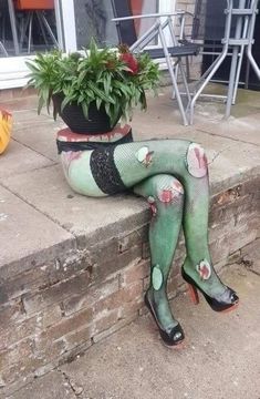 a woman in green stockings and fishnet stockings sitting on steps with potted plants