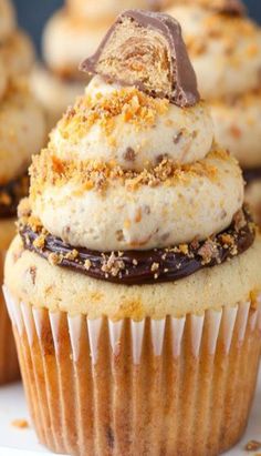 cupcakes with white frosting and chocolate toppings on top, ready to be eaten