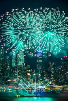 fireworks are lit up in the night sky over a city