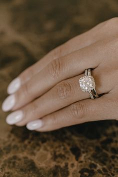 a woman's hand with a diamond ring on it