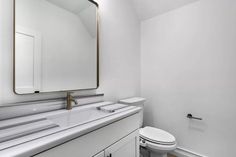 a bathroom with a sink, toilet and mirror in it's center wall area