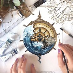 two hands holding a clock with an image of a ship in the ocean on it