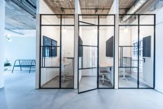 an office with glass partitions and white walls