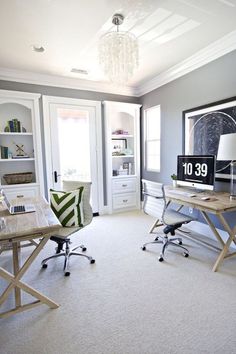 a home office with two desks and a computer monitor on top of the desk