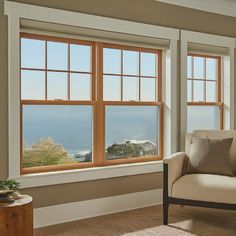 a living room filled with furniture and large windows overlooking the ocean on a sunny day