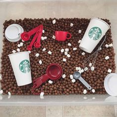 there are coffee cups, spoons, and other items on the tray that is made out of dog food