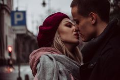 a man and woman kissing on the street