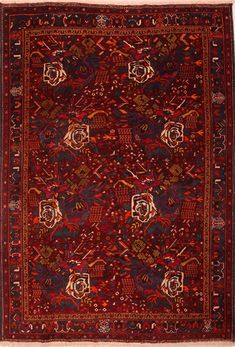 an antique persian rug with red and black design on the center, surrounded by smaller floral designs