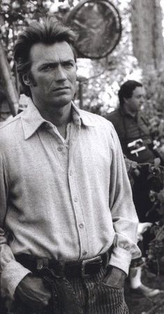 black and white photograph of man standing in front of plants