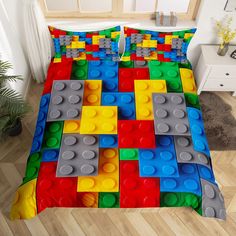 the bed is made up with legos on it's cover and pillows,