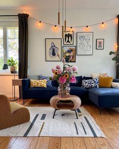 a living room filled with lots of furniture and flowers on the coffee table in front of it