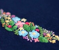 an embroidered piece of cloth with flowers on it