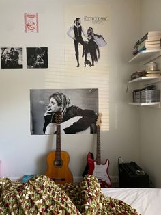 a bedroom with a guitar and pictures on the wall