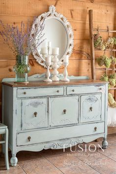 an old dresser has flowers and candles on it