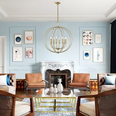 a living room filled with furniture and a chandelier above a fire place in front of a fireplace