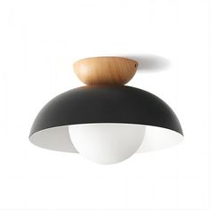 a black and white light fixture with wood on it's top, against a white background