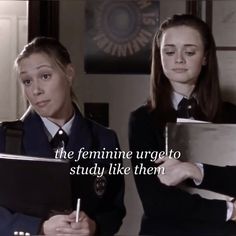 two girls in school uniforms are holding notebooks