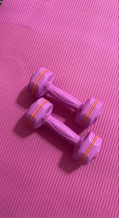 two purple toy cars sitting on top of a pink mat