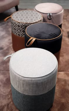 four different colored stools sitting on top of a floor