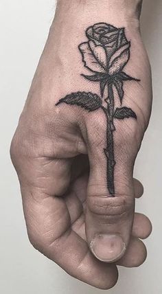 a hand with a rose tattoo on it and a cross in the middle of it