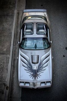 an aerial view of a car parked on the side of the road with wings painted on it