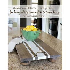 a bowl filled with lemons sitting on top of a wooden serving tray in a kitchen