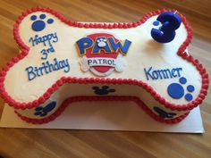 a cake shaped like a dog bone with paw prints on it