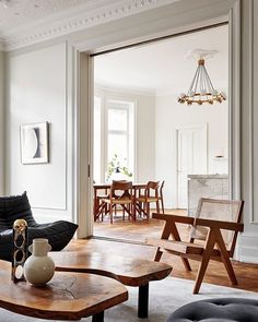 a living room filled with furniture and a wooden coffee table in front of a doorway