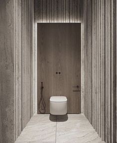 a white toilet sitting in the middle of a bathroom next to a wall with wooden slats on it