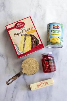 ingredients for cake sitting on top of a white marble counter next to a can of butter