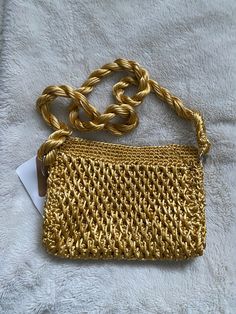 a gold purse sitting on top of a white blanket