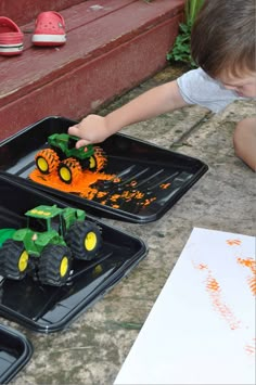 a young boy is playing with toys on the ground